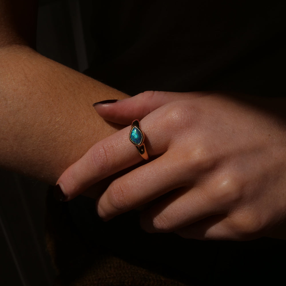 Close up of hand wearing blue opal ring