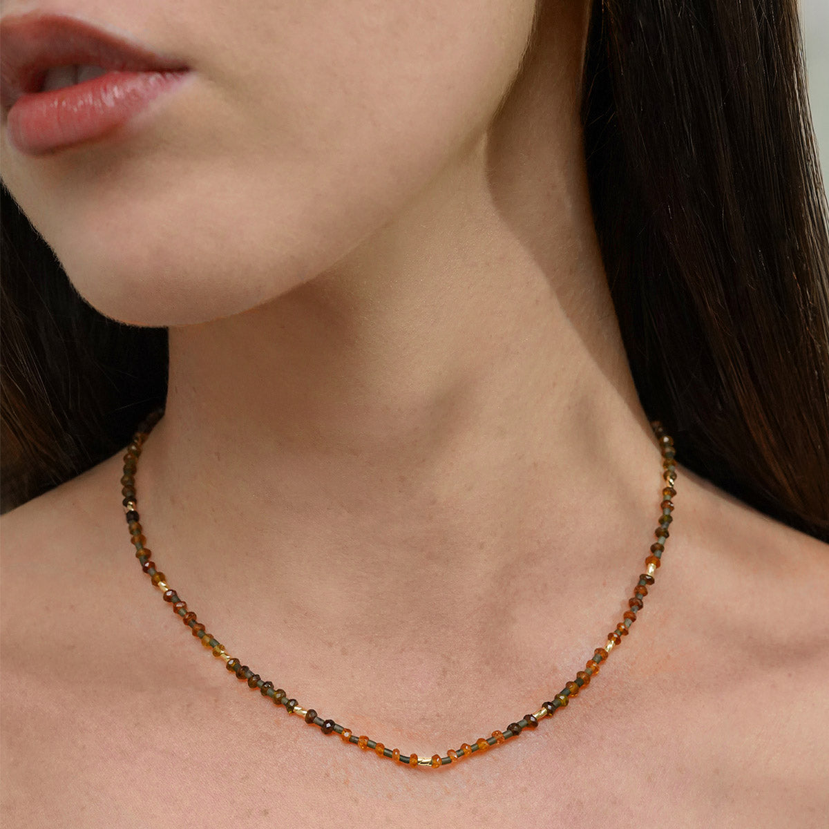 Necklace with tourmaline beads and green serpentine beads in gold worn