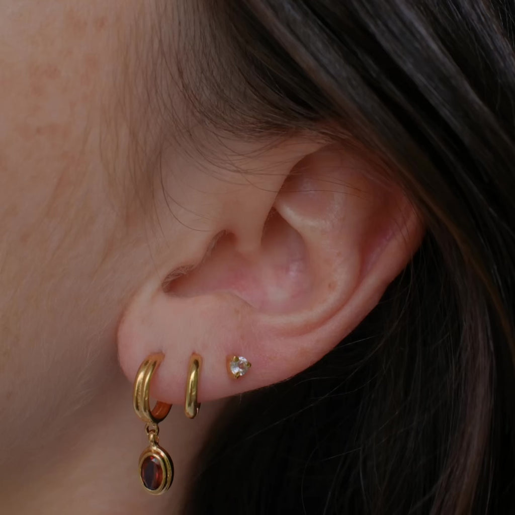 Video of earring stack featuring red garnet earring, hoop and white topaz stud, everyday stack.