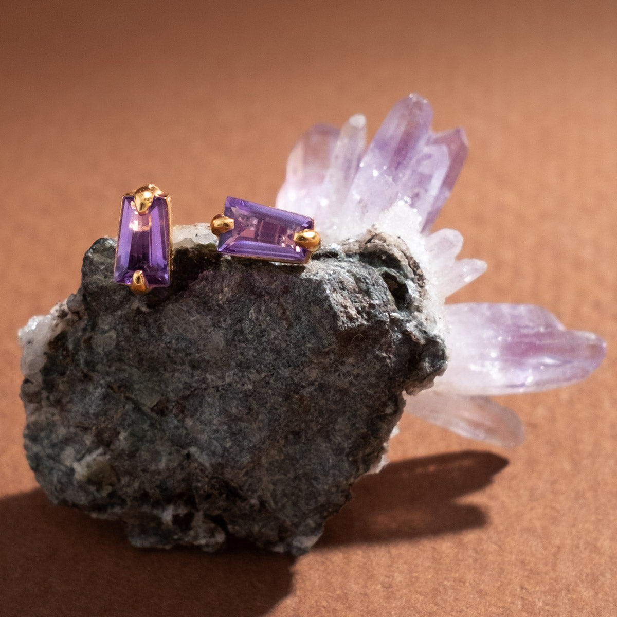 Purple gemstone earrings on a Amethyst crystal